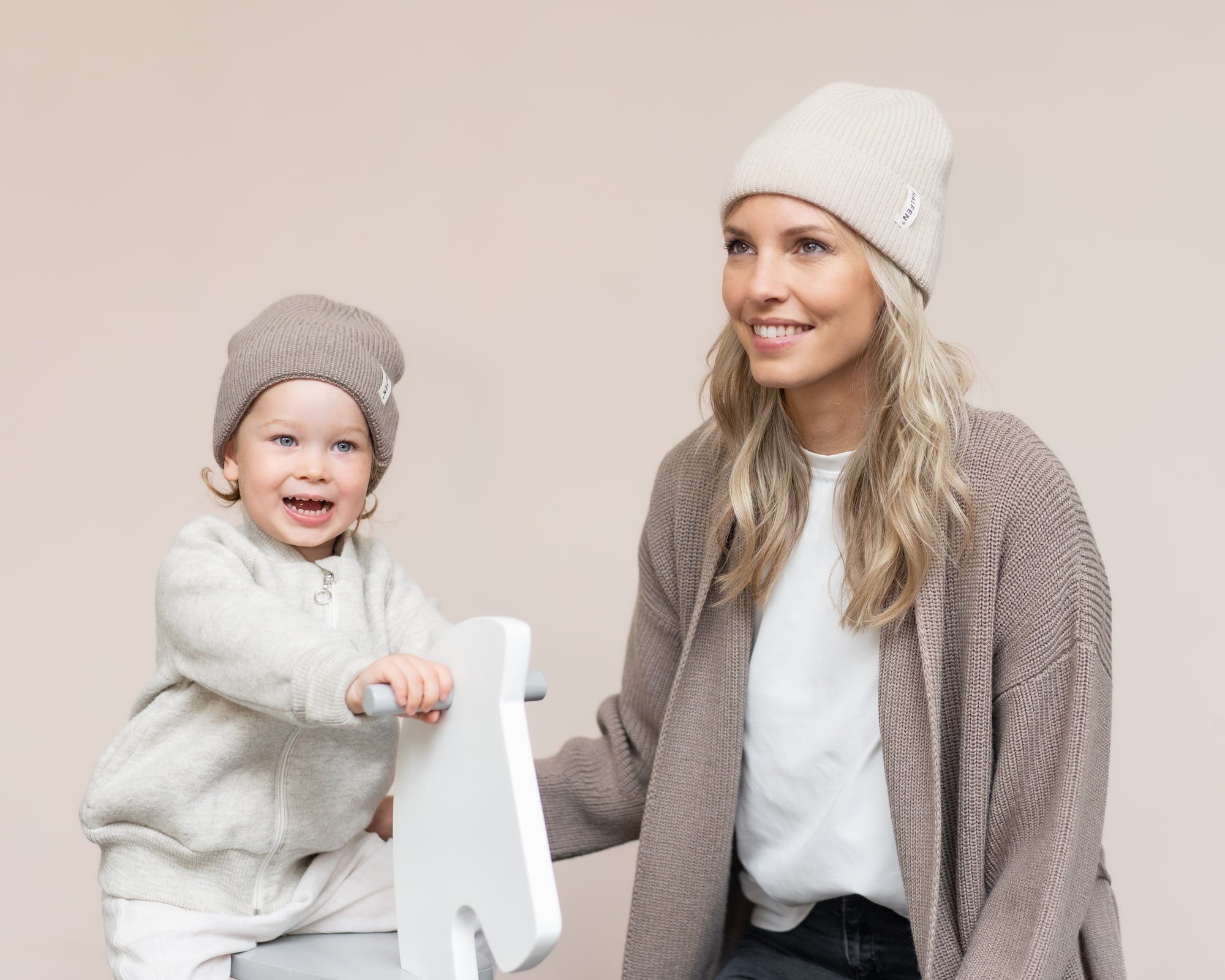 Frau mit Kind in Strickoberteil und Mütze aus Merino