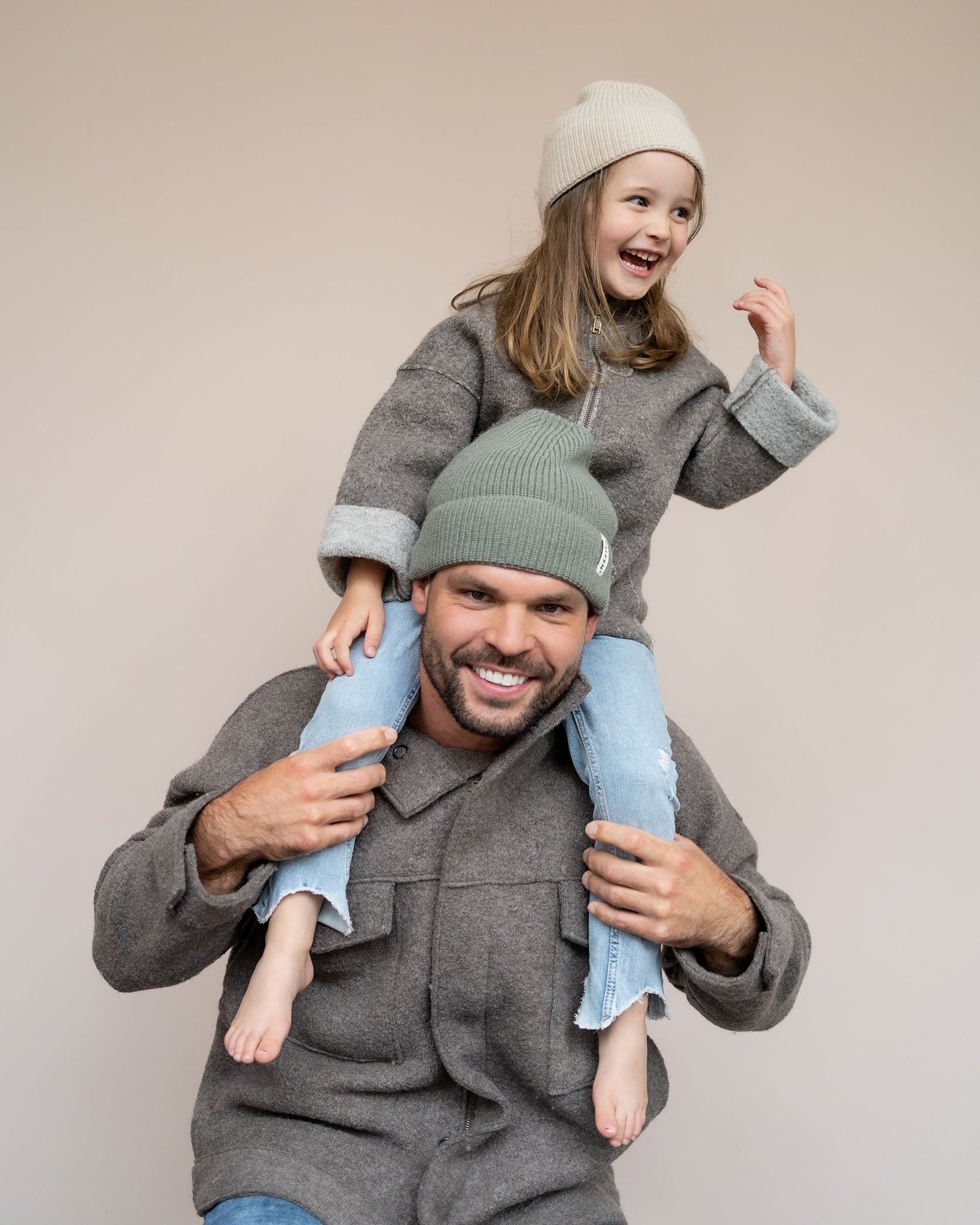 Mann mit Walkjacke und Kind auf den Schultern 