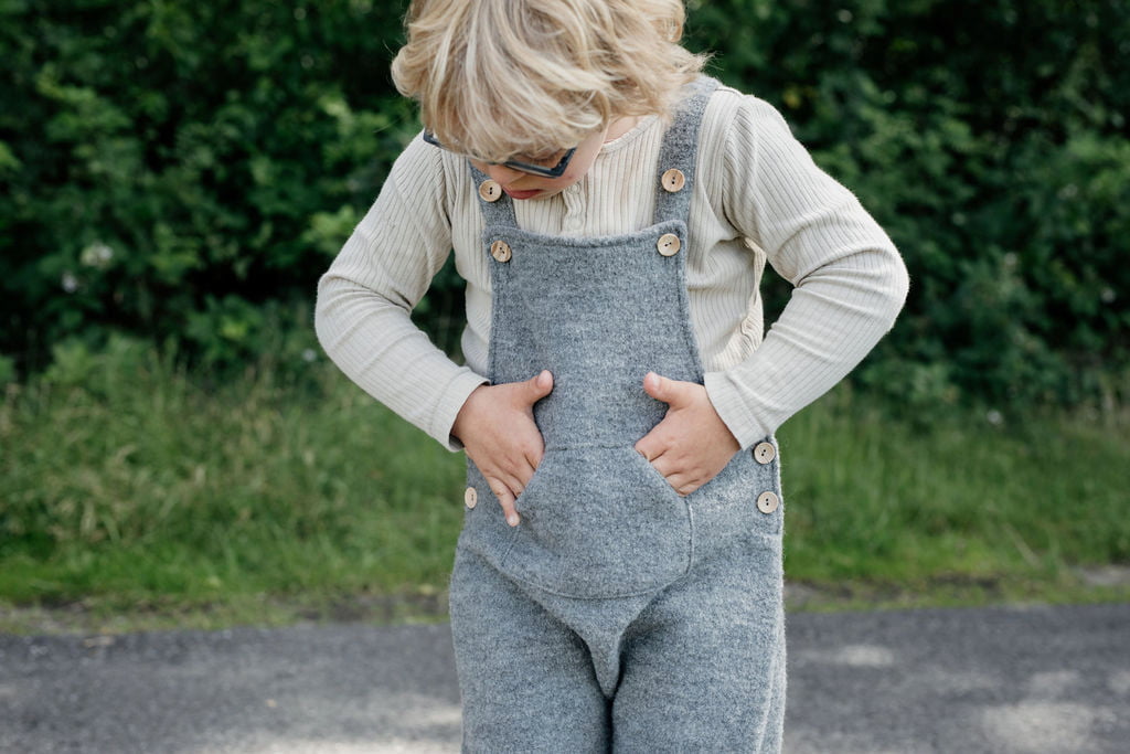 Kind mit Händen in Taschen von Wollwalk Latzhose von Halfen