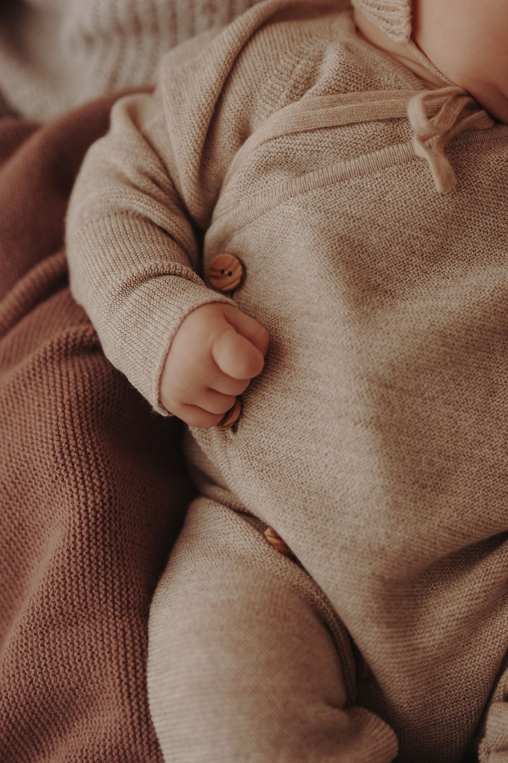 Strickoverall für Babys aus Merinowolle in Mauve– Angezogene Detailansicht 