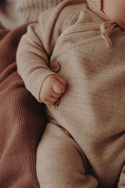 Strickoverall für Babys aus Merinowolle in Mauve– Angezogene Detailansicht 